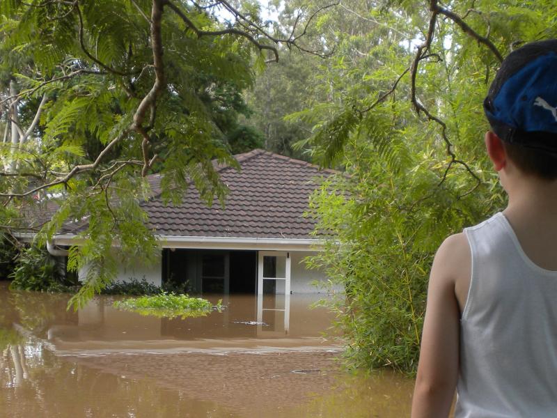 Young boy looking at flooded house